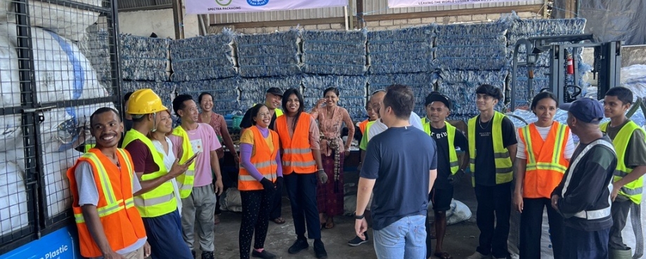 A group of workers stands together at a Prevented Ocean Plastic collection centre.