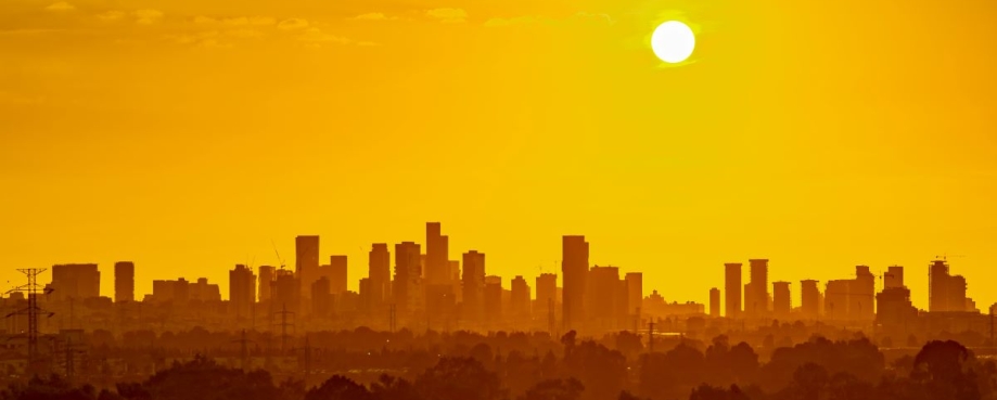 Low sun over a polluted urban skyline