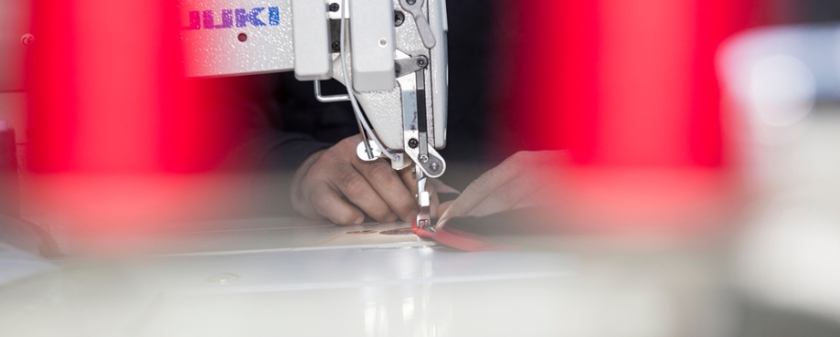 A persons hands working at a sewing machine. Photo credit: Shutterstock.