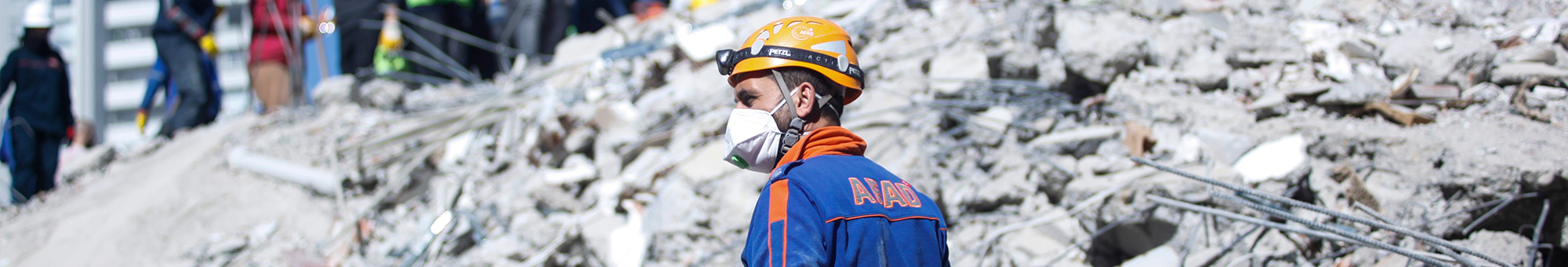A rescue worker surveys the aftermath of an earthquake