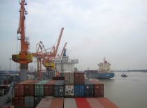 Shipping containers being loaded onto a cargo ship at port. Photo credit: ILO/ Hoa Tran.
